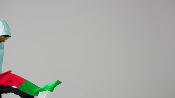 مواجهة الرياح القوية للوصول بالعلم الاماراتي للقمة , امرأة اماراتية ترتدي ملابس التزلج الثقيلة للشعور بالدفء , تثبيت الراية الاماراتية على قمة الجبل , ايماءات السعادة و البهجة بعد الوصول و الانتهاء , الاستمتاع بالاجواء الشتوية المميزة