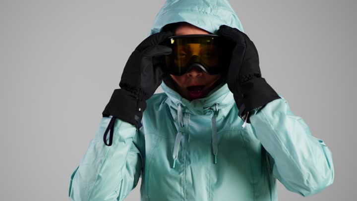 تعديل نظارة التزلج الصفراء على الوجه , امرأة عربية خليجية سعودية ترتدي الملابس الثقيلة للقيام برياضة التزلج على الجليد , امرأة اماراتية