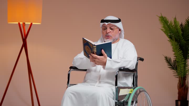 التقرب الى الله بالعبادة و صالح الاعمال , رجل عربي خليجي سعودي يرتدي الغترة البيضاء و الثوب الابيض يقرأ ايات القراءن الكريم , الشعور بالسلام و السكينة