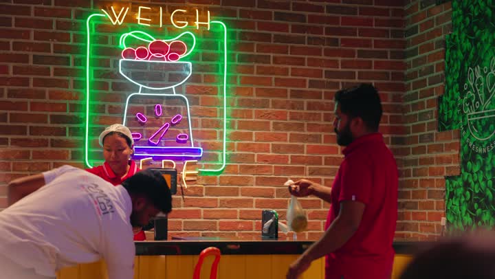 خدمة العملاء وتنظيم العمل داخل السوبر ماركت، تجهيز المنتجات قبل الدفع ،عمال عربيون خليجيون اماراتيون يرتدون الزي الموحد يقفون أمام ميزان إلكتروني لتحديد وزن المنتجات، مفهوم التسوق وبيع المواد الغذائية الطازجة