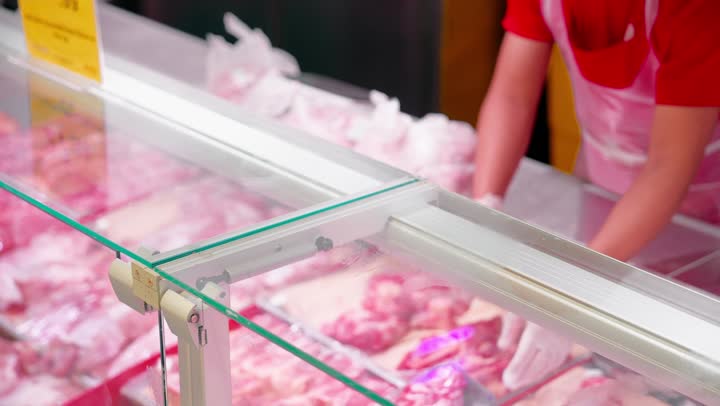 اختيار وشراء اللحوم الطازجة داخل السوبر ماركت، تصوير مقرب لرجل عربي خليجي اماراتي يقوم بالإشارة إلى قطعة لحم داخل ثلاجة العرض، التسوق اليومي وشراء المواد الغذائية من قسم الجزارة، مفهوم اختيار المنتجات بعناية قبل الشراء، خدمة العملاء داخل متجر