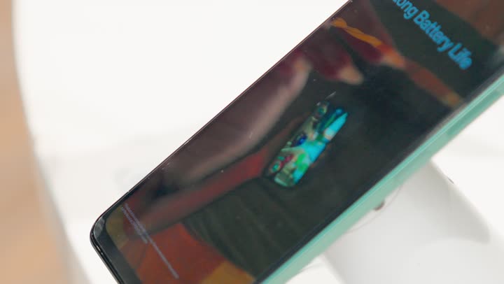 تصوير مقرب لهاتف ذكي حديث يتم عرضه داخل متجر إلكترونيات، إظهار شاشة الهاتف والتصميم الخارجي للجهاز، مفهوم التكنولوجيا الحديثة، تطور الهواتف الذكية، جودة الشاشات الرقمية، عرض المنتجات التقنية