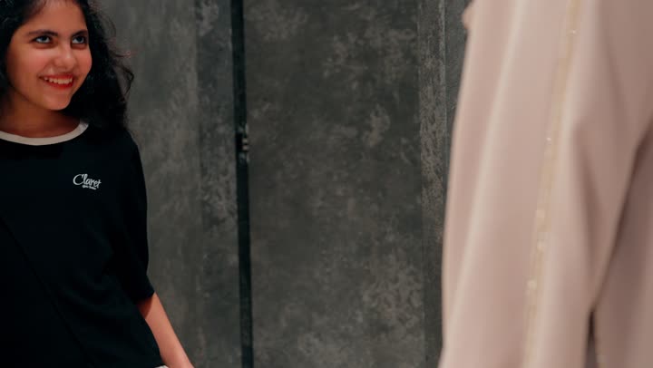 الأناقة الطفولية والاهتمام بالمظهر، بنت عربية خليجية امارتية تقوم بتجربة بلوزة داخل متجر ملابس برفقة والدتها، التسوق العائلي داخل المتاجر التجارية، تجربة تسوق ممتعة للأطفال