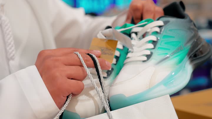 اختيار الحذاء المناسب بعناية، التسوق داخل متجر أحذية، تصوير مقرب ليد رجل عربي خليجي إماراتي يتفقد الأحذية الرجالية المعروضة على الأرفف، مفهوم الأناقة والراحة