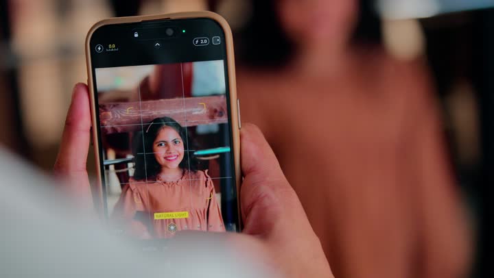 التقاط صورة تذكارية بالهاتف المحمول، تصوير مقرب ليد رجل عربي خليجي اماراتي يقوم بتصوير ابنته عبر الجوال، مفهوم الذكريات العائلية والتقنية الحديثة