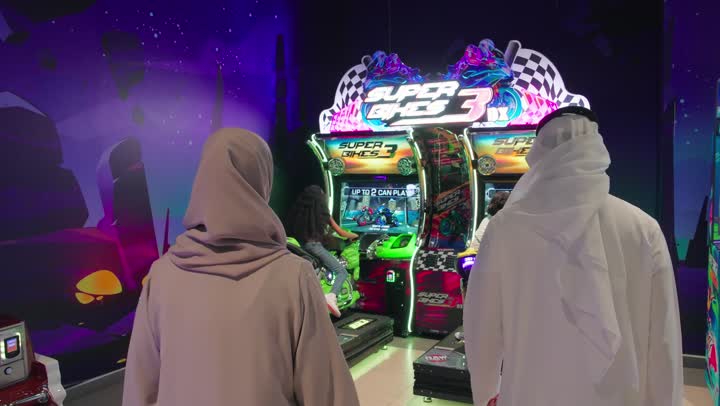 The entertaining recreational centers in the United Arab Emirates, spending happy times in the land of fun, an Arab Gulf Emirati family enjoying playing in the amusement park, feelings of enjoyment and joy, the concept of entertainment and amusement.
