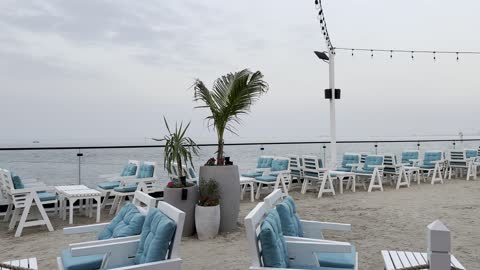 An outdoor seating area overlooking the sea with a recreational atmosphere, a collection of restaurants and cafes facing the sea, the tourist waterfront in the Kingdom of Saudi Arabia in the city of Jubail Industrial, Jubail Corniche, famous tourist attractions.