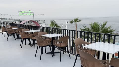 A spacious outdoor seating area at a café on the beach, a collection of restaurants and cafés overlooking the sea, the tourist waterfront in the Kingdom of Saudi Arabia in the city of Jubail Industrial on December 28, 2025, Jubail Corniche, famous tourist attractions.