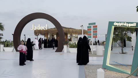 A number of people wearing traditional clothing, the tourist waterfront in the Kingdom of Saudi Arabia in the city of Jubail Industrial on December 28, 2025, a group of restaurants and cafes overlooking the sea, Jubail Corniche, famous tourist attractions.