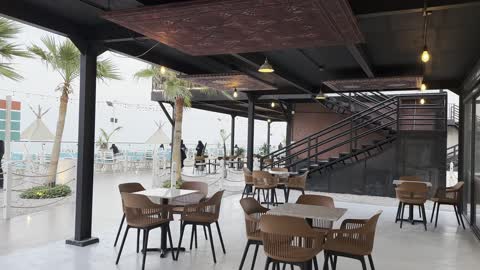 A spacious outdoor seating area at a café on the beach, a collection of restaurants and cafés overlooking the sea, the tourist waterfront in the Kingdom of Saudi Arabia in the city of Jubail Industrial on December 28, 2025, Jubail Corniche, famous tourist attractions.