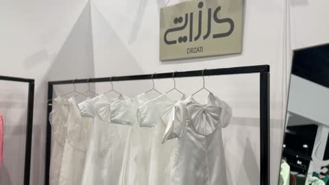 The latest fashion and accessory trends at the Designers' Exhibition in the Eastern Province on December 29, 2025, Saudi Arabia, direct interaction with visitors, a creative platform for fashion and design, highlighting identity and innovation, an upscale atmosphere inside the exhibition.