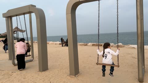قضاء الاطفال وقت ممتع باللعب على الارجوحة، ممشى همس في مدينة الدمام في المنطقة الشرقية في 28 ديسمبر، جلسات ومقاعد خارجية، ممارسة رياضة المشي، جو عائلي هادئ ، وجهة ترفيهية مفتوحة، مساحة للمشي والاسترخاء