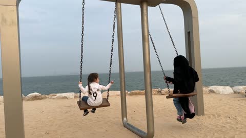 قضاء الاطفال وقت ممتع باللعب على الارجوحة، ممشى همس في مدينة الدمام في المنطقة الشرقية في 28 ديسمبر، جلسات ومقاعد خارجية، ممارسة رياضة المشي، جو عائلي هادئ ، وجهة ترفيهية مفتوحة، مساحة للمشي والاسترخاء