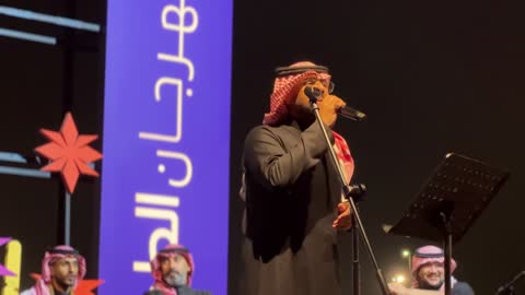 عازف كمان على المسرح وعازف على آلة وترية، فرقة موسيقية تقليدية على خشبة مسرح مضاءة، مهرجان إثراء للطعام من ٢٢ ديسمبر حتى ع يناير ٢٠٢٦، مركز الملك عبد العزيز للثقافة العالمية (إثراء) في الظهران في المملكة العربية السعودية، تصميم فريد يشبه الحصى