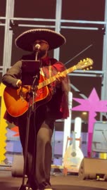 رجل على المسرح بزي قبعة المارياتشي التقليدية ويعزف على الجيتار، مهرجان إثراء للطعام من ٢٢ ديسمبر حتى ع يناير ٢٠٢٦، رقصة فولكلورية مكسيكية، مركز الملك عبد العزيز للثقافة العالمية (إثراء) في الظهران في المملكة العربية السعودية، تصميم فريد يشبه الحصى