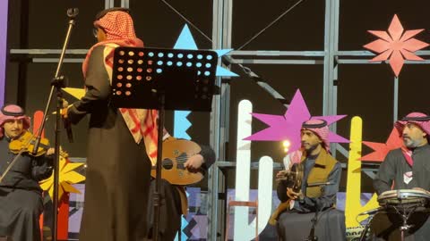 شركة مصرية متخصصة في التمور والمنتجات الغذائية الأخرى، فرقة موسيقية تقليدية على خشبة مسرح مضاءة، مهرجان إثراء للطعام من ٢٢ ديسمبر حتى ع يناير ٢٠٢٦، مركز الملك عبد العزيز للثقافة العالمية (إثراء) في الظهران في المملكة العربية السعودية، تصميم فريد يشبه الحصى