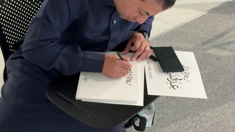 رجل يقوم بالكتابة بالخط العربي في معرض اللغة العربية للكبارفى مقر مجمع الملك سلمان العالمي للغة العربية في حي الورود بالرياض يوم ١١ من ديسمبر 2025، تحقيق رؤية السعودية 2030 في المجال الثقافي،  أنشطة ثقافية وفكرية متنوعة