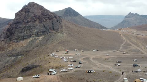 Four-wheel drive vehicles in a desert area, dormant volcanic fields with rugged terrain, important tourist and geological sites, archaeological inscriptions and rock formations, trade caravan routes, volcanic fields in Tabuk, laboratories on ancient volcanic activity in the Kingdom of Saudi Arabia.