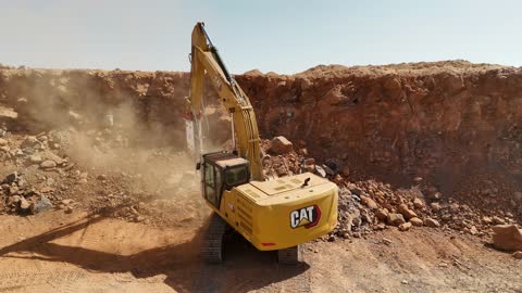 آليات  ضمن عمليات تحريك التربة، عملية تعدين واسعة النطاق في منطقة صحراوية، مصنع أسمنت أو محجر في المملكة العربية السعودية، خلط مكونات الخرسانة ، عجينة اسمنتية للبناء والانشاء ، اماكن انشائية، حواجز خرسانية لفصل المواد المخزنة