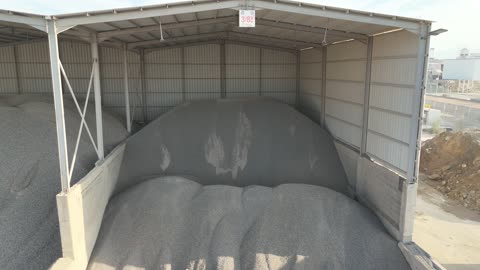 أكوام كبيرة من المواد الخام الحصى، الرمل أو الركام ، مصنع أسمنت أو محجر في المملكة العربية السعودية، خلط مكونات الخرسانة ، عجينة اسمنتية للبناء والانشاء ، اماكن انشائية، حواجز خرسانية لفصل المواد المخزنة