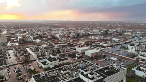 تجمع مياه الأمطار وسط المنطقة، مساحات واسعة من الأراضي المبللة، البرق شريط من الضوء يخترق السماء بسرعة، منخفض جوي، امطار شتوية، أماكن ومناطق السياحة في المملكه العربية السعودية، تصوير درون للسيل في مدينة تبوك