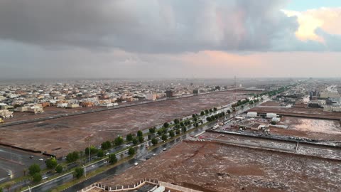 المباني السكنية ذات الطراز المتشابه، البرق شريط من الضوء يخترق السماء بسرعة، منخفض جوي، امطار شتوية، أماكن ومناطق السياحة في المملكه العربية السعودية، تصوير درون للسيل في مدينة تبوك , تجمع مياه الأمطار وسط المنطقة