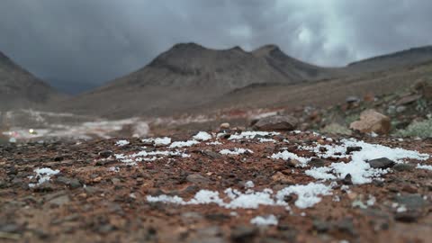 Rare snowfall in the desert, tourist cultural landmarks in the Kingdom of Saudi Arabia, the Al-Harra mountain range in the Tabuk region covered in snow, cold snowy atmosphere, sculpted mountains and rock formations in the city of Tabuk, aerial drone photography of the rock formations.