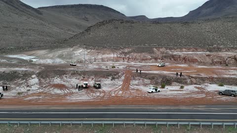 مركبات دفع رباعي في منطقة صحراوية ، سلسلة جبال الحرة في منطقة تبوك تكسوها الثلوج، أجواء ثلجية باردة، جبال منحوتة وتشكيلات جبلية في مدينة تبوك، معالم حضارية سياحية في المملكة العربية السعودية، تصوير درون جوي للتكوينات الصخرية