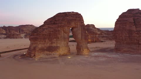 A famous desert area, drone photography of the Elephant Rock in Saudi Arabia, ancient civilization and archaeological historical landmarks, mountain peaks and highlands, rock formation and composition in the city of AlUla.