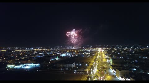 مظاهر الاحتفال والفرح، تصوير درون للمفرقعات والالعاب النارية في سماء مدينة تبوك في وقت الليل، حركة مرور السيارات في شوارع المدينة