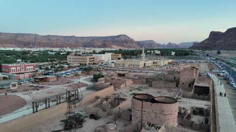 الاشجار والنبات الاخضر، الفن الهندسي المعماري على الطراز الاسلامي، منطقة سياحية مشهورة، الجبال والتكوينات الصخرية، مكان لاداء العبادة والتقرب الى الله تعالى، تصوير درون لمسجد اسلامي في محافظة العلا بالمملكة العربية السعودية