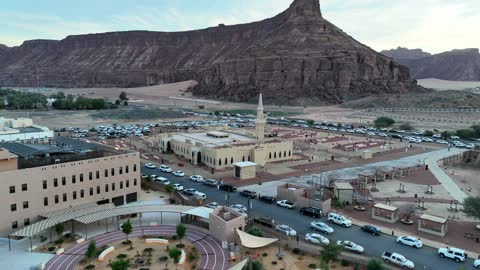 Trees and green plants, architectural art in the Islamic style, a famous tourist area, mountains and rock formations, a place for worship and getting closer to God Almighty, drone photography of an Islamic mosque in Al-Ula Governorate in the Kingdom of Saudi Arabia.