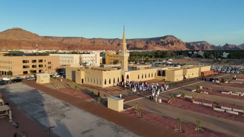 Trees and green plants, architectural art in the Islamic style, a famous tourist area, mountains and rock formations, a place for worship and getting closer to God Almighty, drone photography of an Islamic mosque in Al-Ula Governorate in the Kingdom of Saudi Arabia.