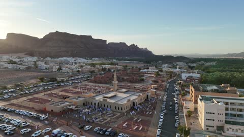 Trees and green plants, architectural art in the Islamic style, a famous tourist area, mountains and rock formations, a place for worship and getting closer to God Almighty, drone photography of an Islamic mosque in Al-Ula Governorate in the Kingdom of Saudi Arabia.