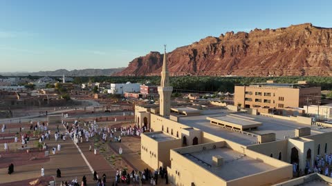 الفن الهندسي المعماري على الطراز الاسلامي، منطقة سياحية مشهورة، الجبال والتكوينات الصخرية، مكان لاداء العبادة والتقرب الى الله تعالى، تصوير درون لمسجد اسلامي في محافظة العلا بالمملكة العربية السعودية، الاشجار والنبات الاخضر