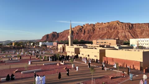 Islamic architectural engineering art, a famous tourist area, mountains and rock formations, a place for worship and getting closer to God Almighty, drone photography of an Islamic mosque in Al-Ula Governorate in the Kingdom of Saudi Arabia, trees and green plants.
