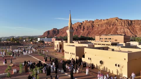 الفن الهندسي المعماري على الطراز الاسلامي، منطقة سياحية مشهورة، الجبال والتكوينات الصخرية، مكان لاداء العبادة والتقرب الى الله تعالى، تصوير درون لمسجد اسلامي في محافظة العلا بالمملكة العربية السعودية، الاشجار والنبات الاخضر