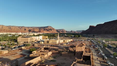 The mountains and rock formations, a place for worship and getting closer to God Almighty, a drone shot of an Islamic mosque in Al-Ula Governorate in the Kingdom of Saudi Arabia, trees and green plants, a famous tourist area.
