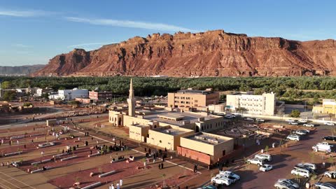 The mountains and rock formations, a place for worship and getting closer to God Almighty, a drone shot of an Islamic mosque in Al-Ula Governorate in the Kingdom of Saudi Arabia, trees and green plants, a famous tourist area.