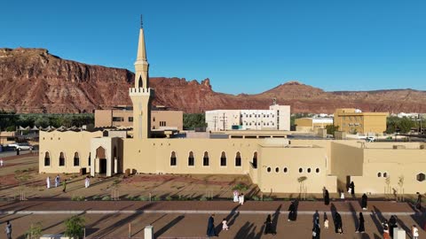 الفن الهندسي المعماري على الطراز الاسلامي، منطقة سياحية مشهورة، الجبال والتكوينات الصخرية، مكان لاداء العبادة والتقرب الى الله تعالى، تصوير درون لمسجد اسلامي في محافظة العلا بالمملكة العربية السعودية، الاشجار والنبات الاخضر