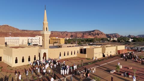 الفن الهندسي المعماري على الطراز الاسلامي، منطقة سياحية مشهورة، الجبال والتكوينات الصخرية، مكان لاداء العبادة والتقرب الى الله تعالى، تصوير درون لمسجد اسلامي في محافظة العلا بالمملكة العربية السعودية، الاشجار والنبات الاخضر