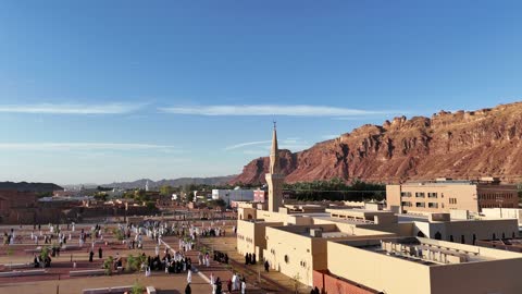 The mountains and rock formations, a place for worship and getting closer to God Almighty, a drone shot of an Islamic mosque in Al-Ula Governorate in the Kingdom of Saudi Arabia, trees and green plants, a famous tourist area.
