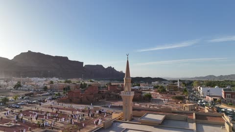 الاشجار والنبات الاخضر، الفن الهندسي المعماري على الطراز الاسلامي، منطقة سياحية مشهورة، الجبال والتكوينات الصخرية، مكان لاداء العبادة والتقرب الى الله تعالى، تصوير درون لمسجد اسلامي في محافظة العلا بالمملكة العربية السعودية