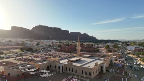 الفن الهندسي المعماري على الطراز الاسلامي، منطقة سياحية مشهورة، الجبال والتكوينات الصخرية، مكان لاداء العبادة والتقرب الى الله تعالى، تصوير درون لمسجد اسلامي في محافظة العلا بالمملكة العربية السعودية، الاشجار والنبات الاخضر