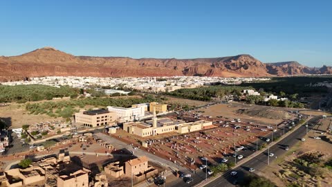 The mountains and rock formations, a place for worship and getting closer to God Almighty, a drone shot of an Islamic mosque in Al-Ula Governorate in the Kingdom of Saudi Arabia, trees and green plants, a famous tourist area.