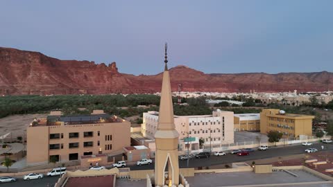 معلم ومكان لاداء العبادة والتقرب الى الله تعالى، الاشجار والنبات الاخضر، الفن الهندسي المعماري على الطراز الاسلامي، منطقة سياحية مشهورة، الجبال والتكوينات الصخرية، تصوير درون لمسجد اسلامي في محافظة العلا بالمملكة العربية السعودية