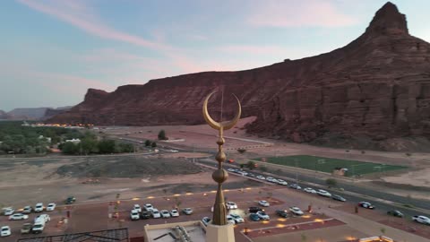 A place for worship and getting closer to God Almighty, trees and green plants, architectural art in the Islamic style, a famous tourist area, mountains and rock formations, drone photography of an Islamic mosque in Al-Ula Governorate in the Kingdom of Saudi Arabia.