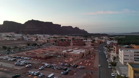 A landmark and place for worship and getting closer to God Almighty, trees and green plants, architectural art in the Islamic style, a famous tourist area, mountains and rock formations, drone photography of an Islamic mosque in Al-Ula Governorate in the Kingdom of Saudi Arabia.