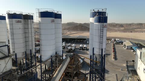 Concrete mixing station, a factory specialized in ready-mixed concrete works and mechanical foundations, mixing concrete components, cement paste for construction and building, construction sites, large piles of raw materials gravel, mixing different components to produce concrete.