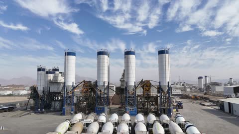 محطات مركزية خاصة بالمصنع، إنتاج الخرسانة لمشاريع البناء والهندسة المدنية ، مصنع متخصص في أعمال الخرسانة الجاهزة والأساسات الميكانيكية ، خلط مكونات الخرسانة ، عجينة اسمنتية للبناء والانشاء ، أكوام كبيرة من المواد الخام الحصى